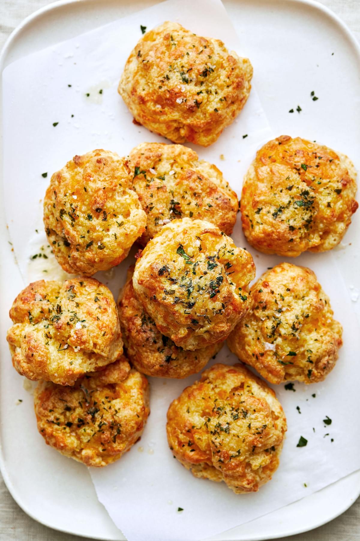 homemade red lobster cheddar bay biscuits topped with melted butter and spices (salt, onion, garlic and parsley) on a plate