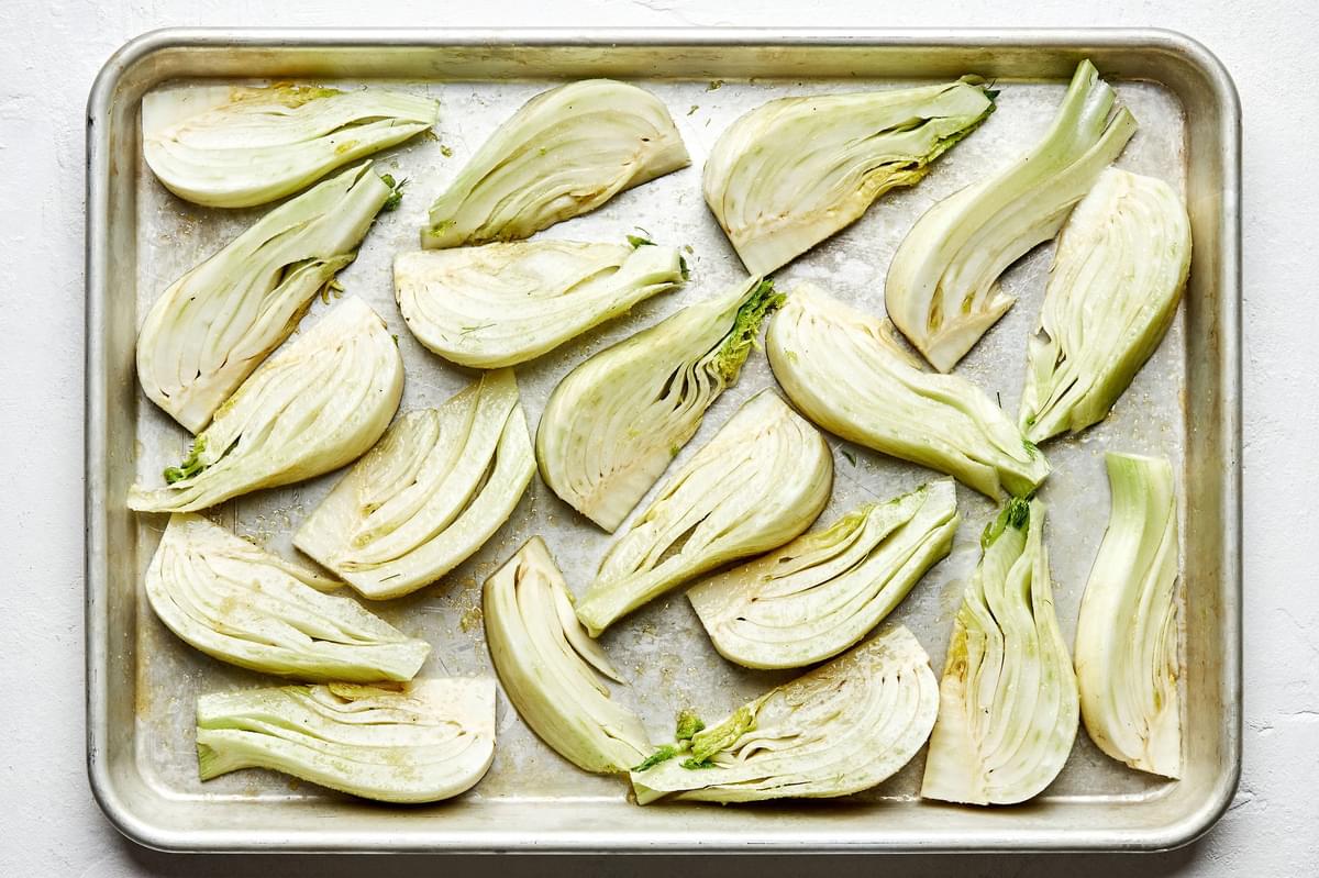 raw fennel sliced on a baking sheet tossed with olive oil, salt, garlic powder and pepper