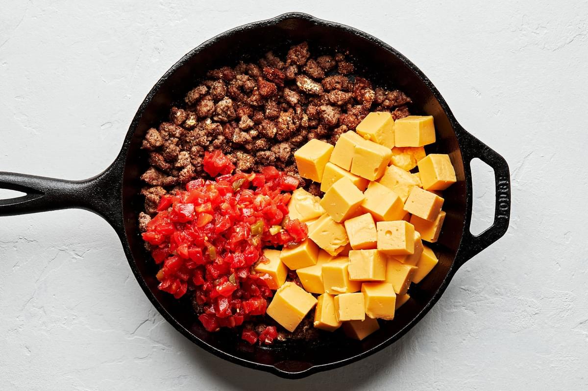 seasoned browned ground beef, velvet cheese, and canned rotel tomatoes in a skillet to make rotel dip