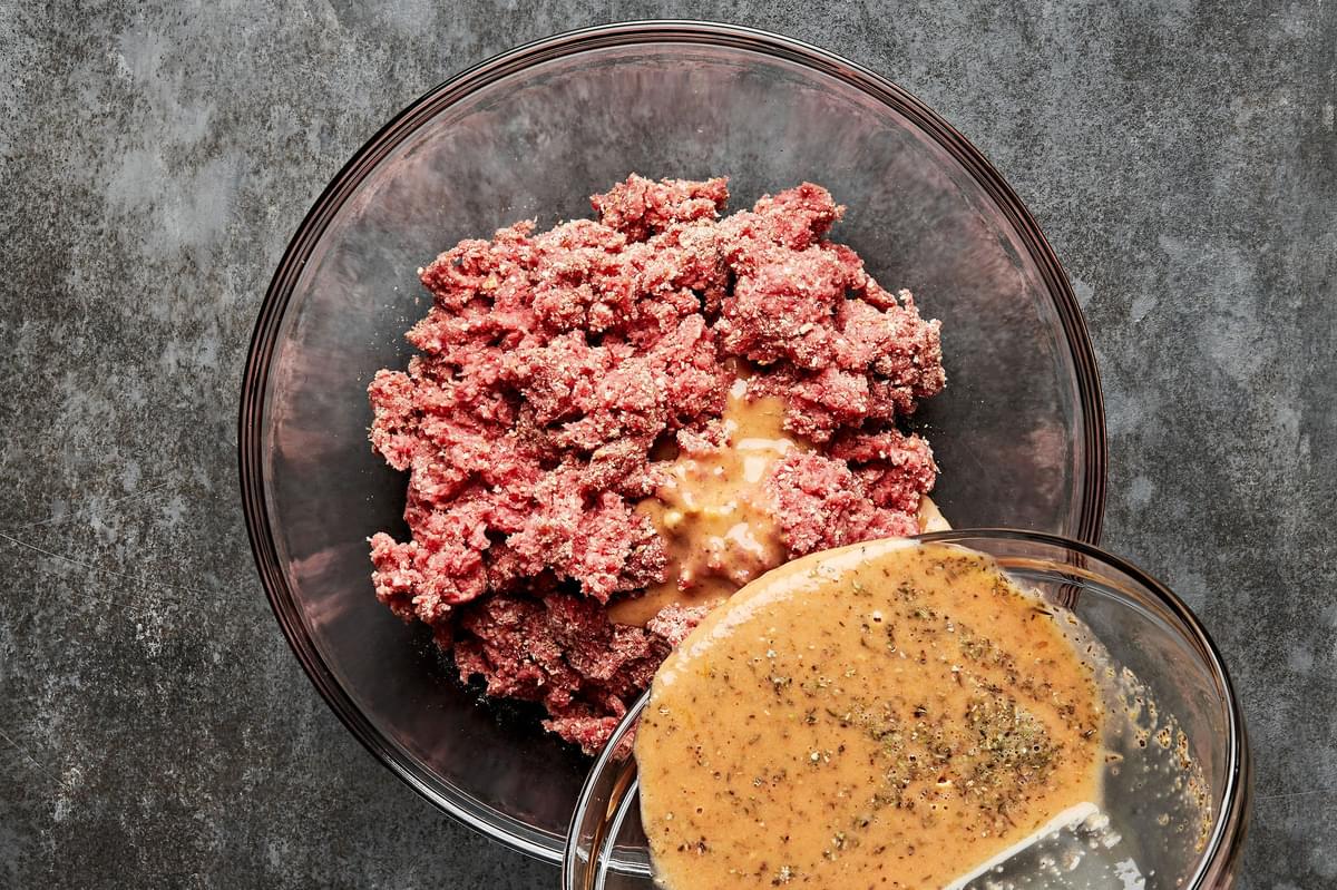 egg mixture being poured into a bowl with ground beef and breadcrumb mixture for making salisbury steak patties