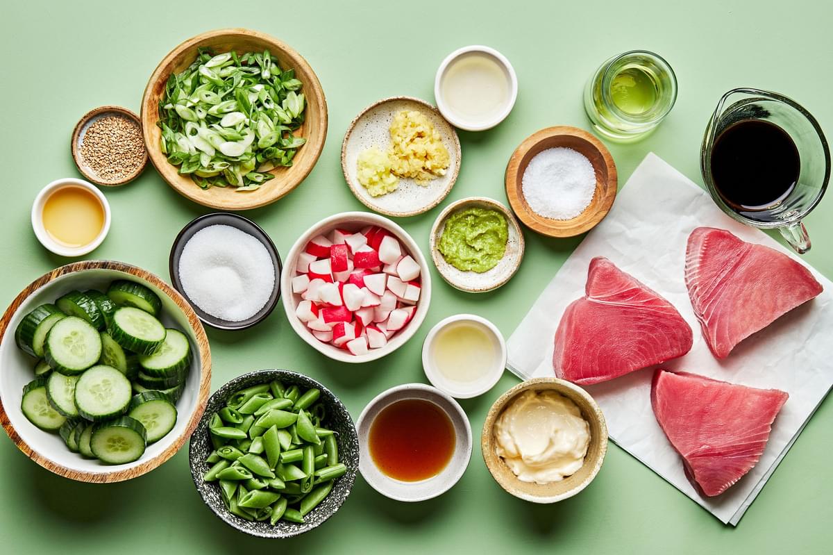 raw ahi tuna, soy sauce, cucumbers, snap peas, radishes, mayo, wasabi, sesame oil, rice vinegar, garlic and ginger in bowls