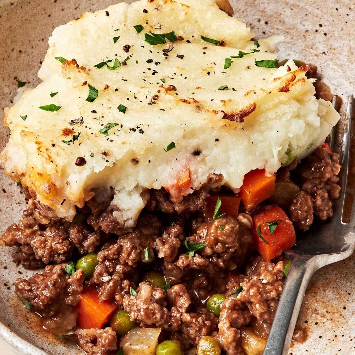 a slice of homemade shepherd's pie in a bowl with a fork
