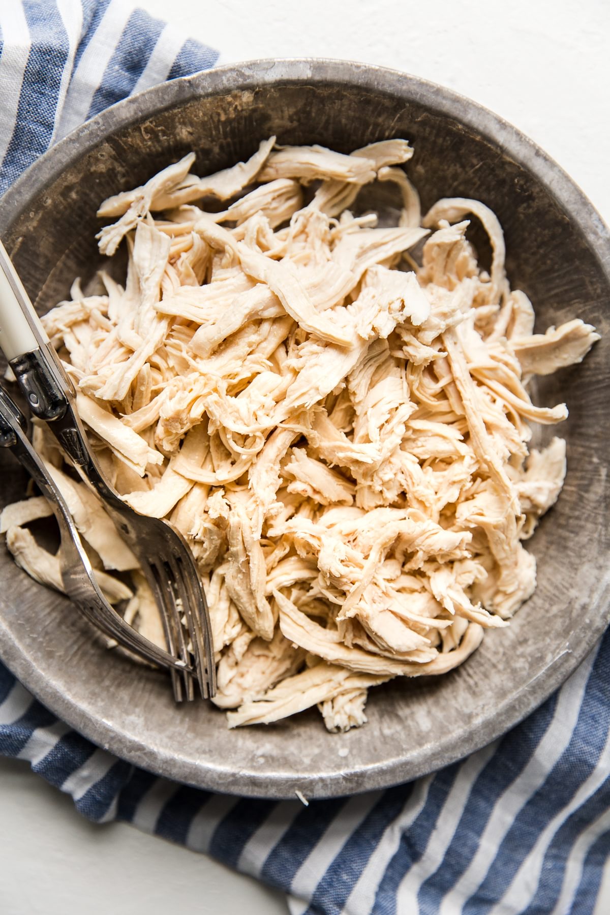 perfectly shredded chicken in a bowl with a fork