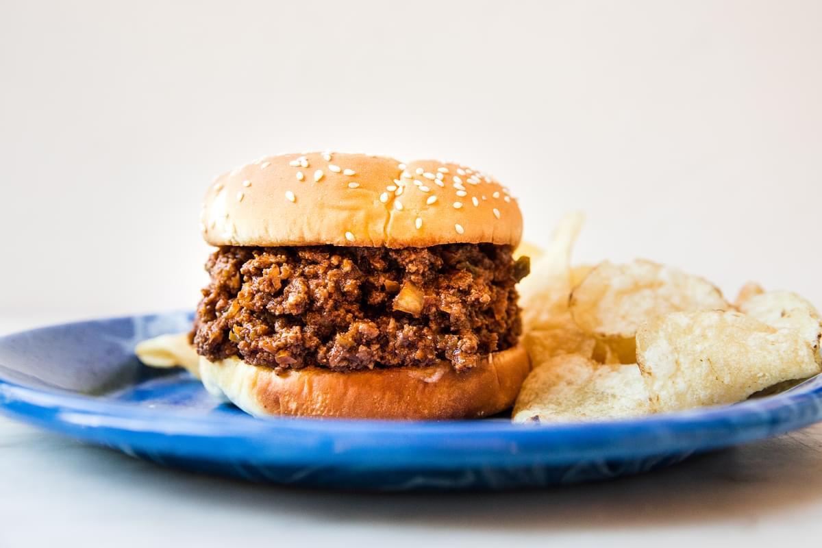homemade sloppy Joe recipe on a plate next to chips