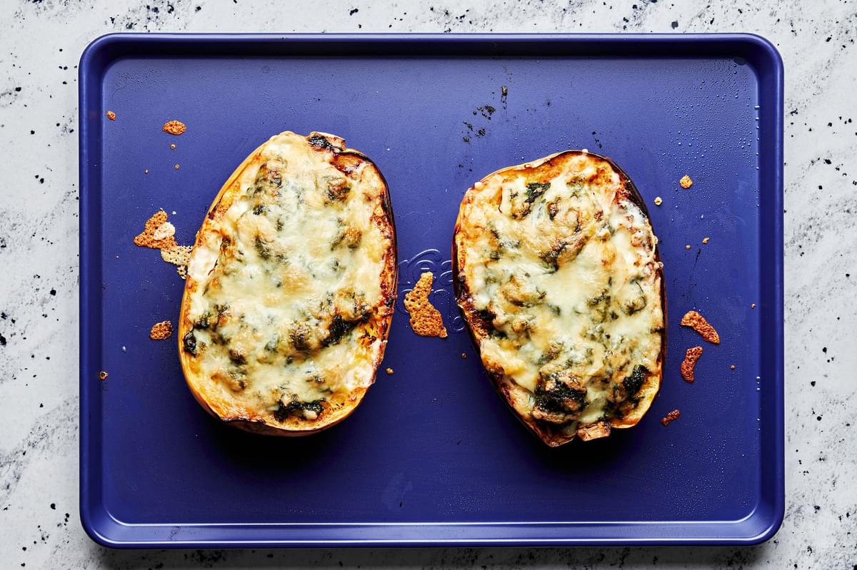 roasted Spaghetti Squash filled with Creamed Spinach, Chicken and mozzarella, topped with parmesan on a baking sheet