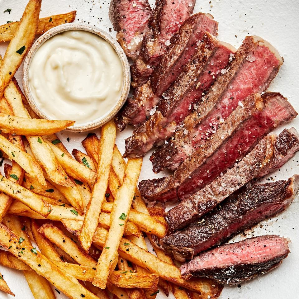 Homemade Steak Frites on plate served with garlic aioli
