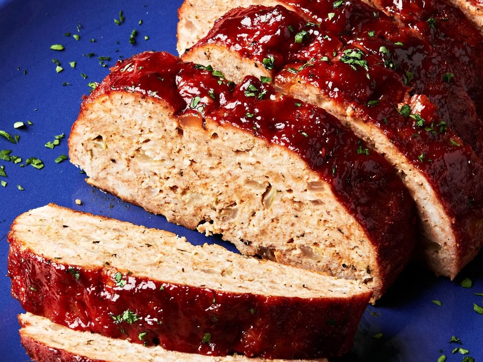 homemade turkey meatloaf with a brown sugar sauce sliced on a serving plate