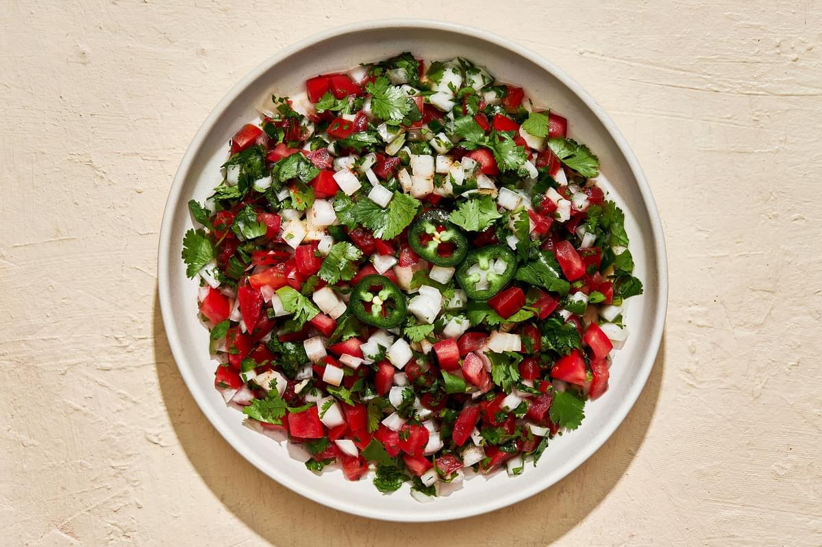 homemade pico de Gallo in a serving bowl made with Roma tomatoes, White onion, cilantro, Jalapeñoes, Limes and Salt