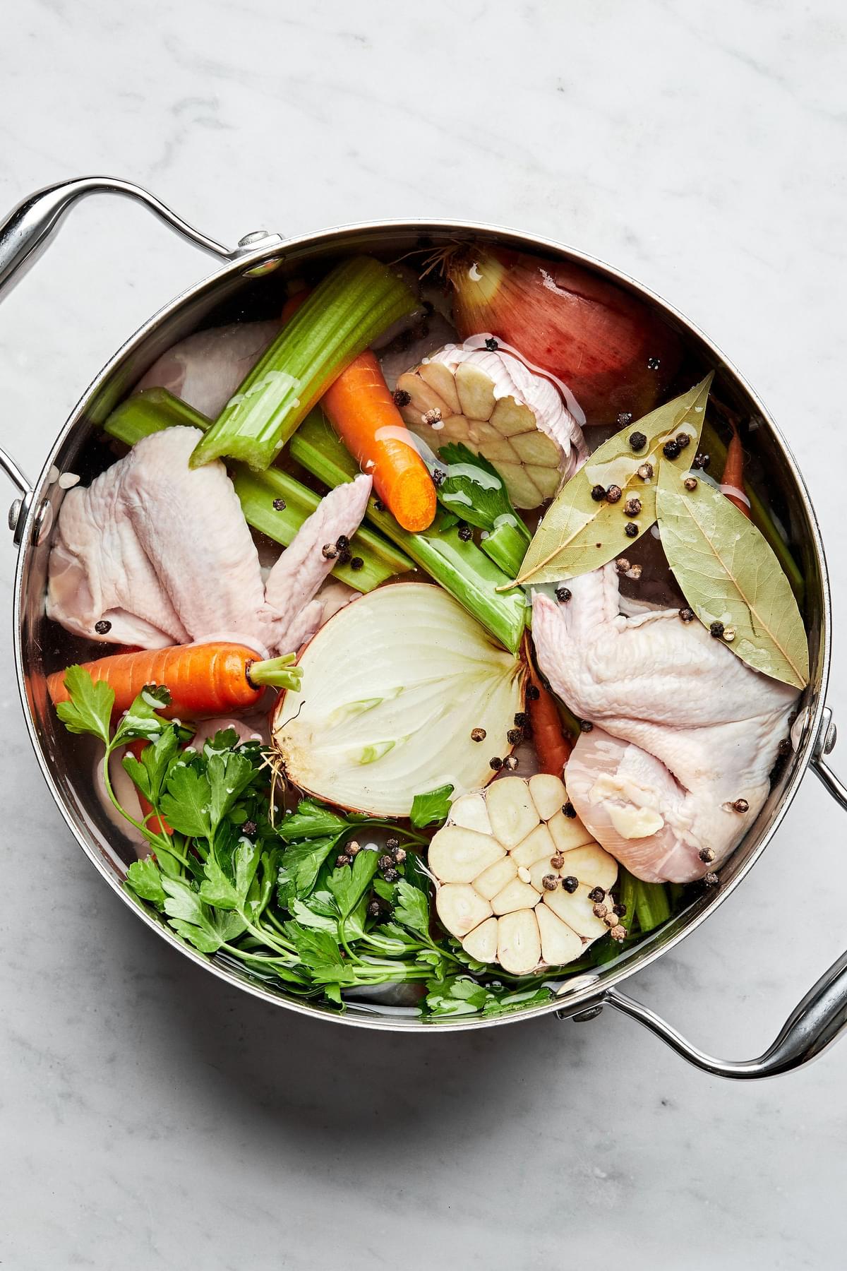 chicken parts, onion, carrot, celery, garlic, herbs and spices in a large pot to make homemade chicken stock