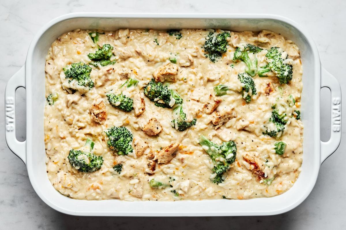 rice, chicken, broccoli and sauce mixed together in a casserole baking dish