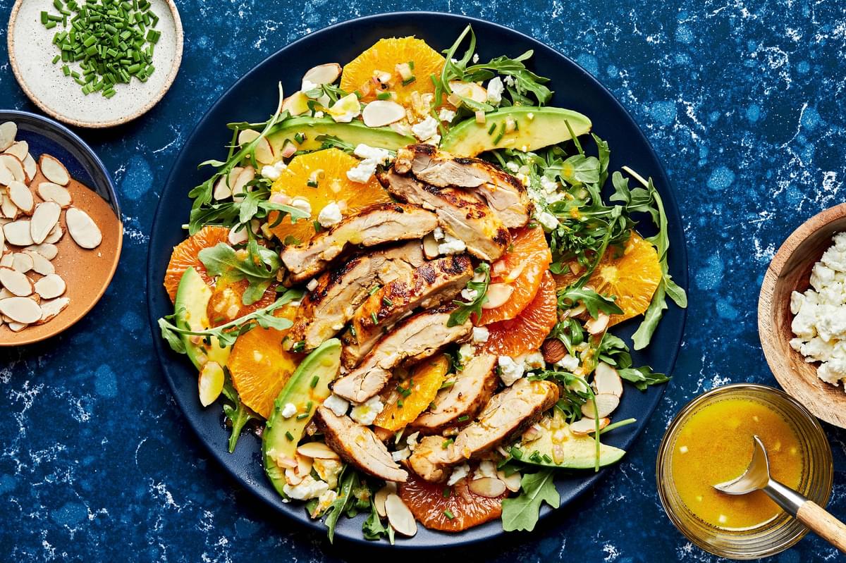 arugula drizzled with citrus dressing topped with chicken, avocado, feta, orange, almonds and chives