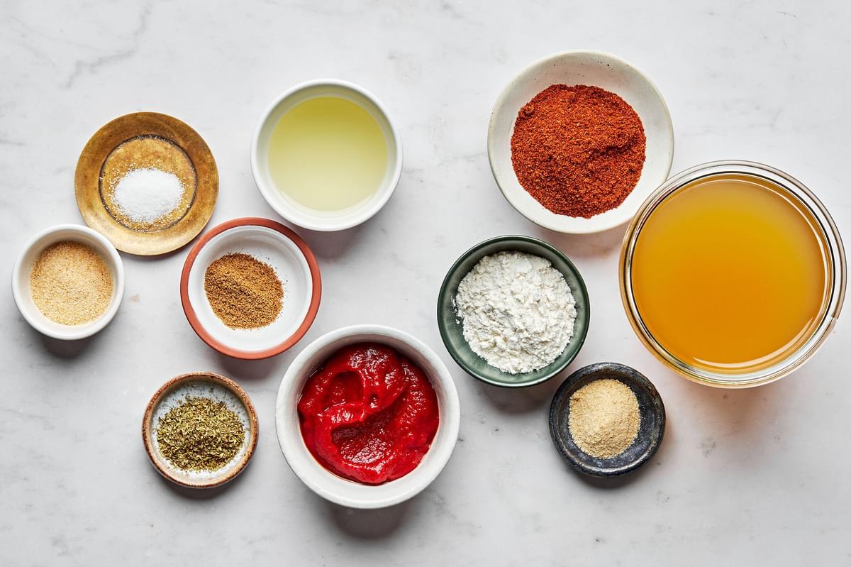 vegetable oil, flour, chili powder, garlic powder, onion powder, cumin, oregano, tomato paste and stock in prep bowls