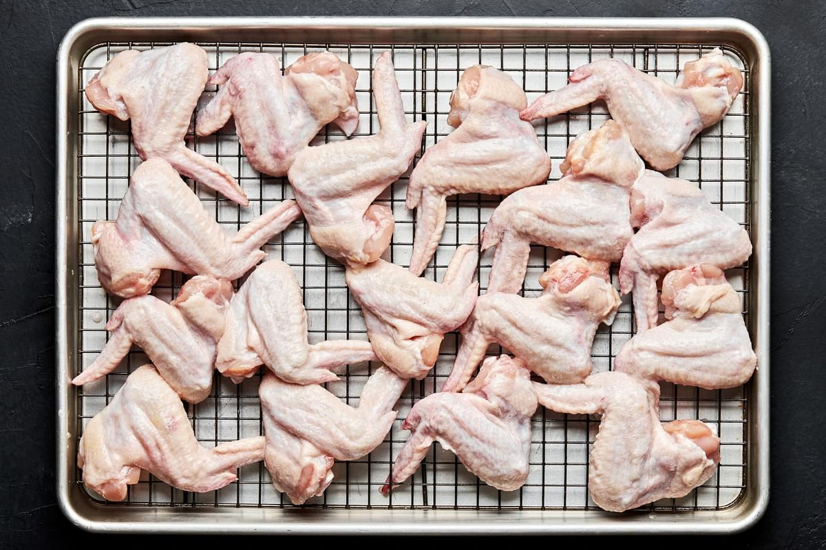 chicken wings that have been coated in egg whites on a wire rack on top of a baking sheet