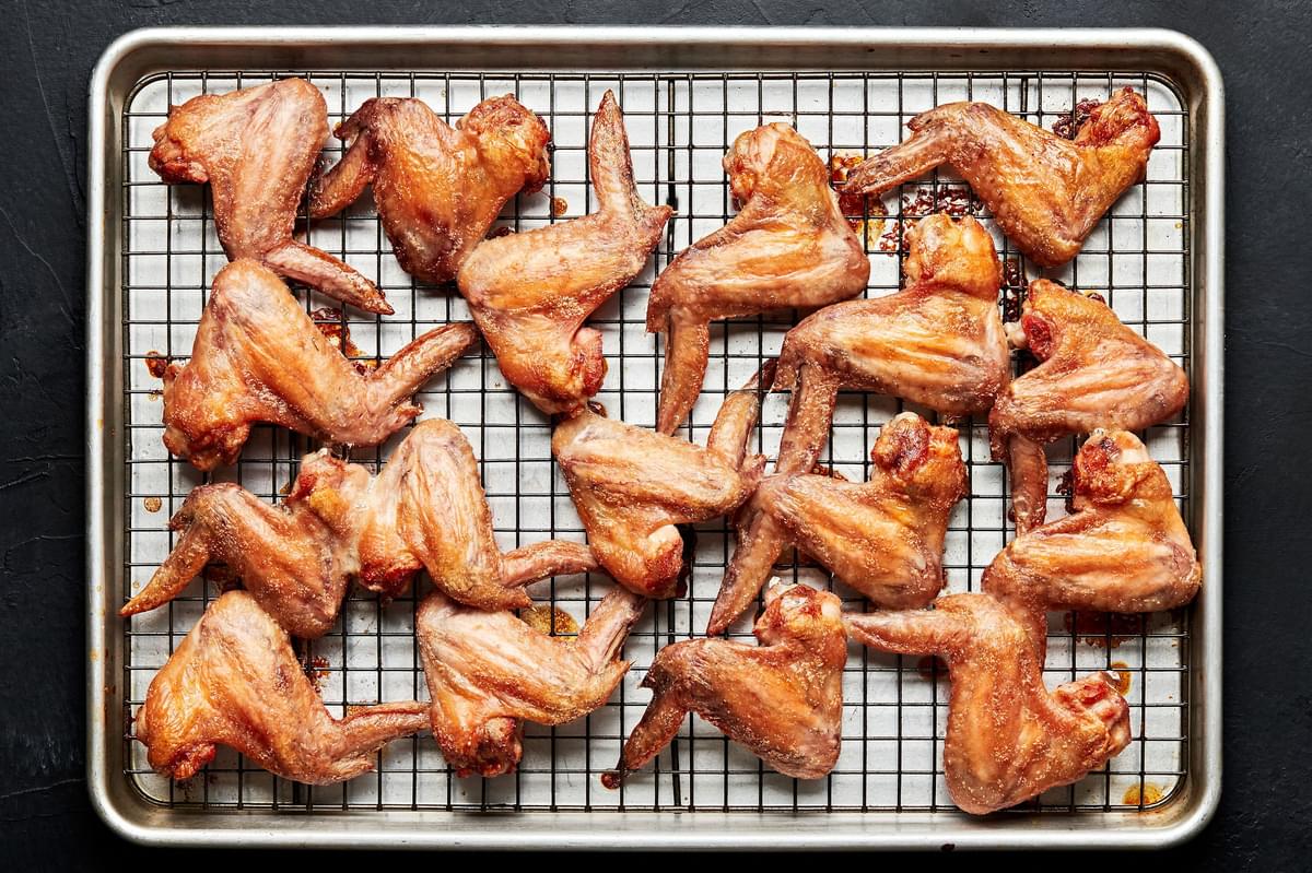 baked chicken wings on a wire rack on top of a baking sheet