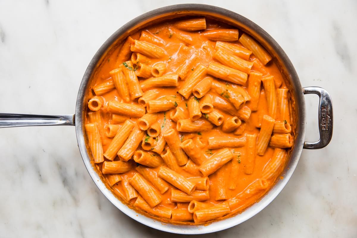 pink sauce tortiglioni pasta in a pan made with tomatoes, spices, cream, parmesan and basil