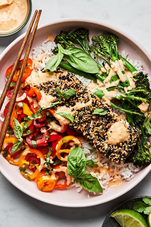 Sesame crusted salmon and broccolini on top of rice served with pepper salad and drizzled with chili tahini sauce.