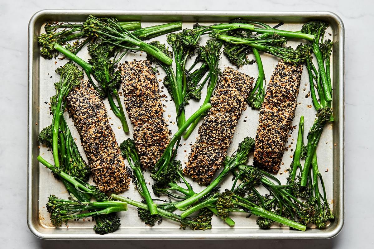 sesame crusted salmon and broccolini on a baking sheet