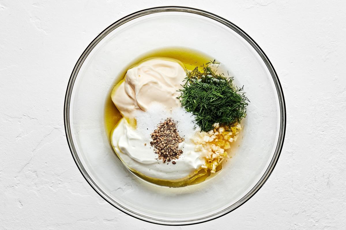 mayonnaise, yogurt, olive oil, garlic, fresh minced dill, vinegar, salt, pepper, and sugar in a small glass bowl