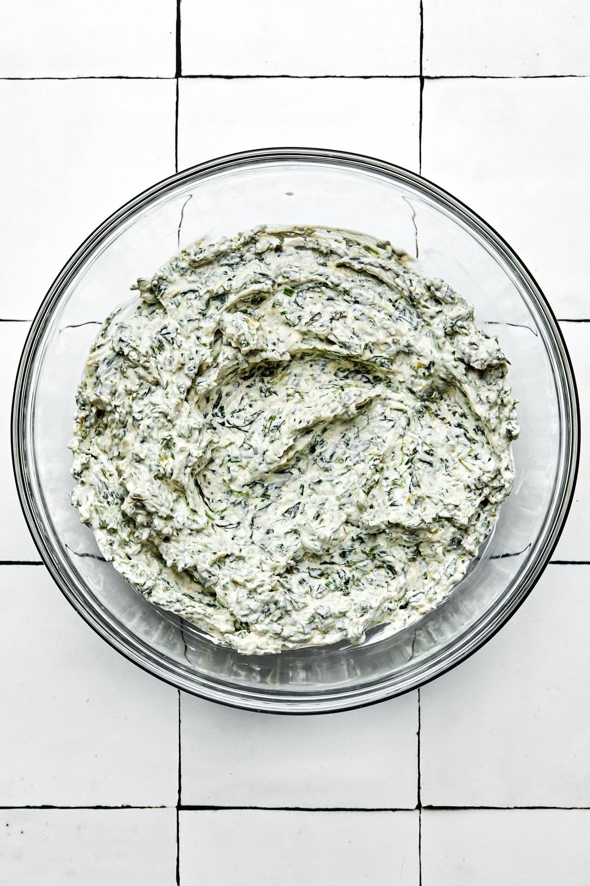 homemade spinach dip in a glass bowl made with sour cream, mayonnaise, spinach, spices, Worcestershire, dijon and chives