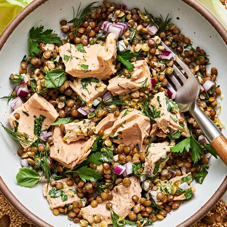 tuna lentil salad in a bowl made with lentils, tuna, mayo, dijon, lemon zest & juice, spices, fresh herbs, red onion & capers