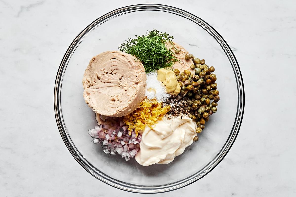 tuna, mayonnaise, capers, onions, lemon zest, lemon juice, dill, mustard, salt, and pepper in a glass bowl