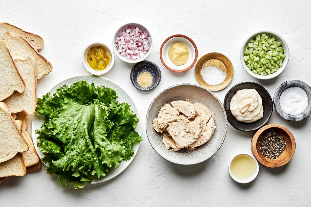 tuna, shallot, celery, relish, mayonnaise, Dijon, lemon juice, spices, bread and lettuce in prep bowls for tuna salad