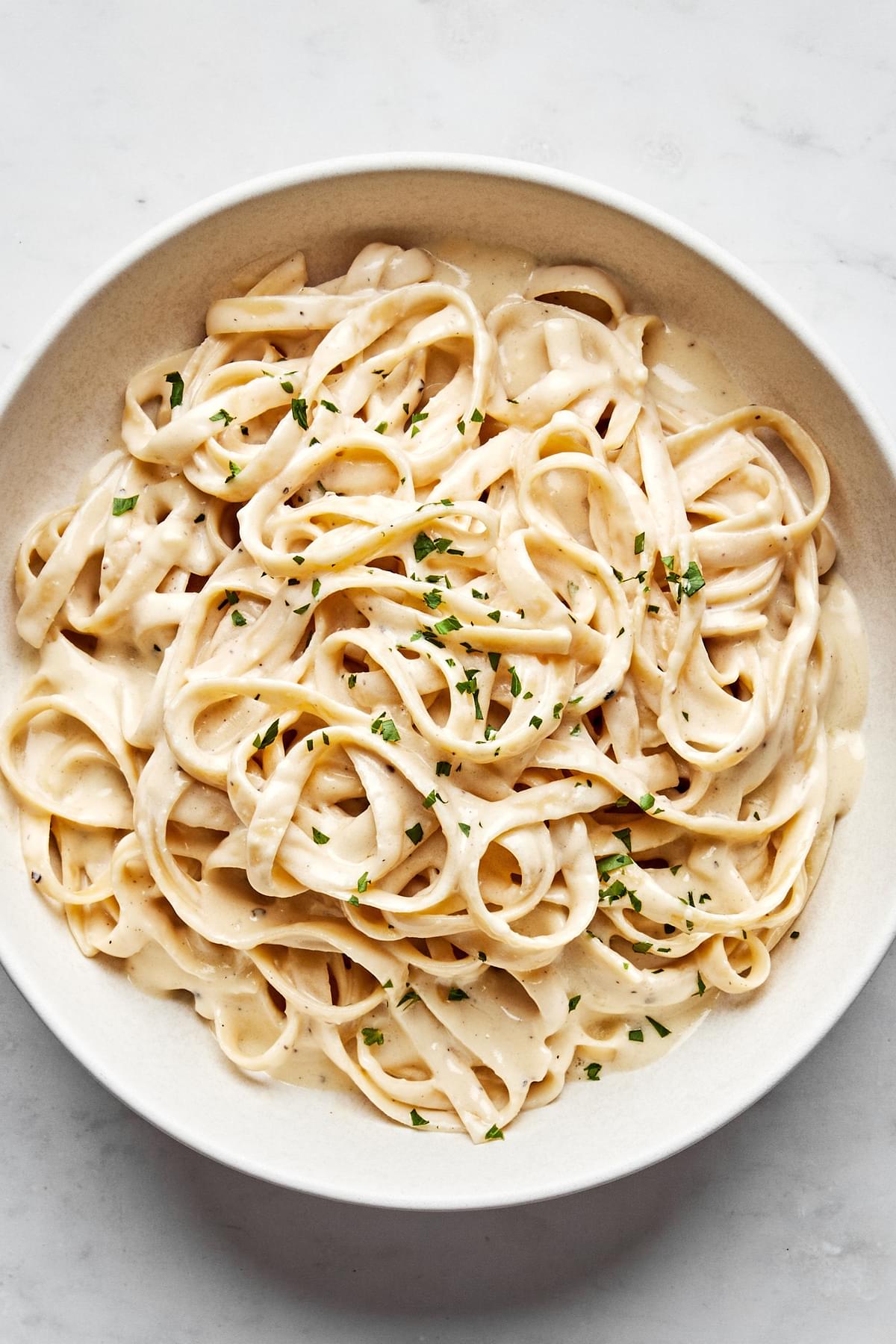 homemade alfredo sauce tossed with fettuccine noodles topped with fresh parsley
