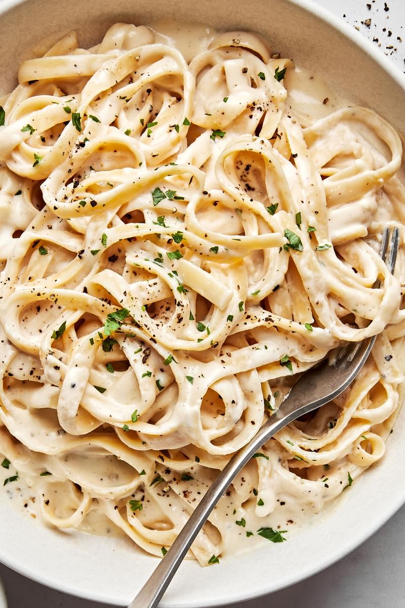 homemade alfredo sauce tossed with fettuccine noodles topped with fresh parsley