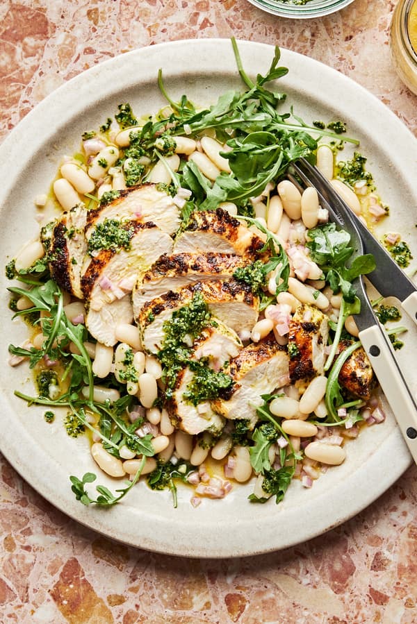 Arugula and White Bean salad with Pesto chicken on a serving platter