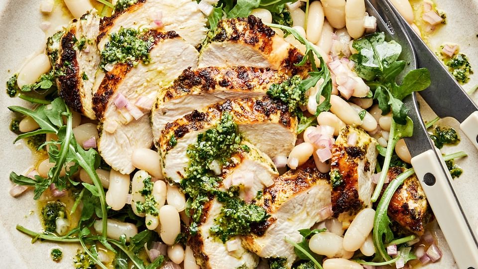 Arugula and White Bean salad with Pesto chicken on a serving platter