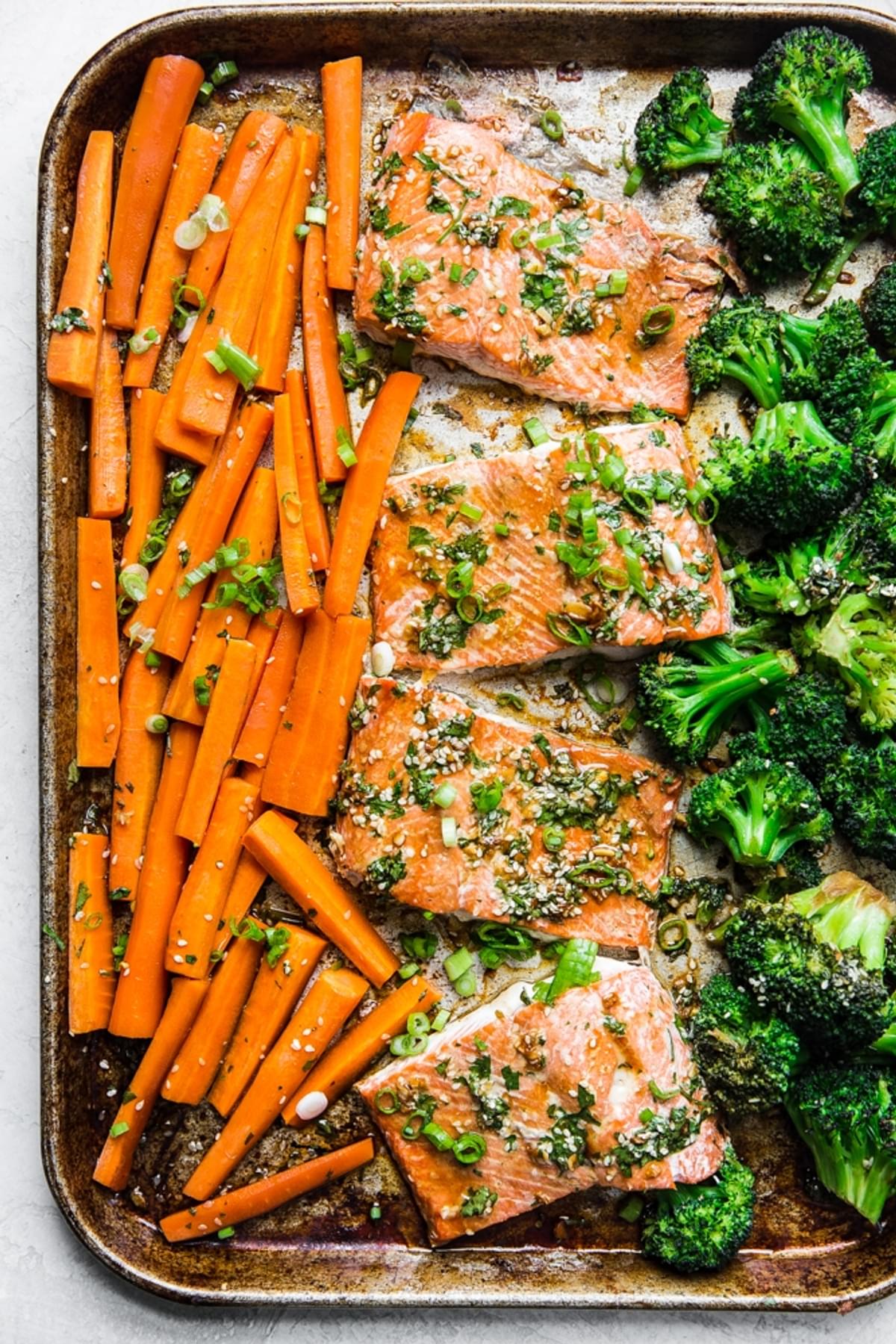 Baking sheet with carrots, salmon and broccoli with a teriyaki sauce