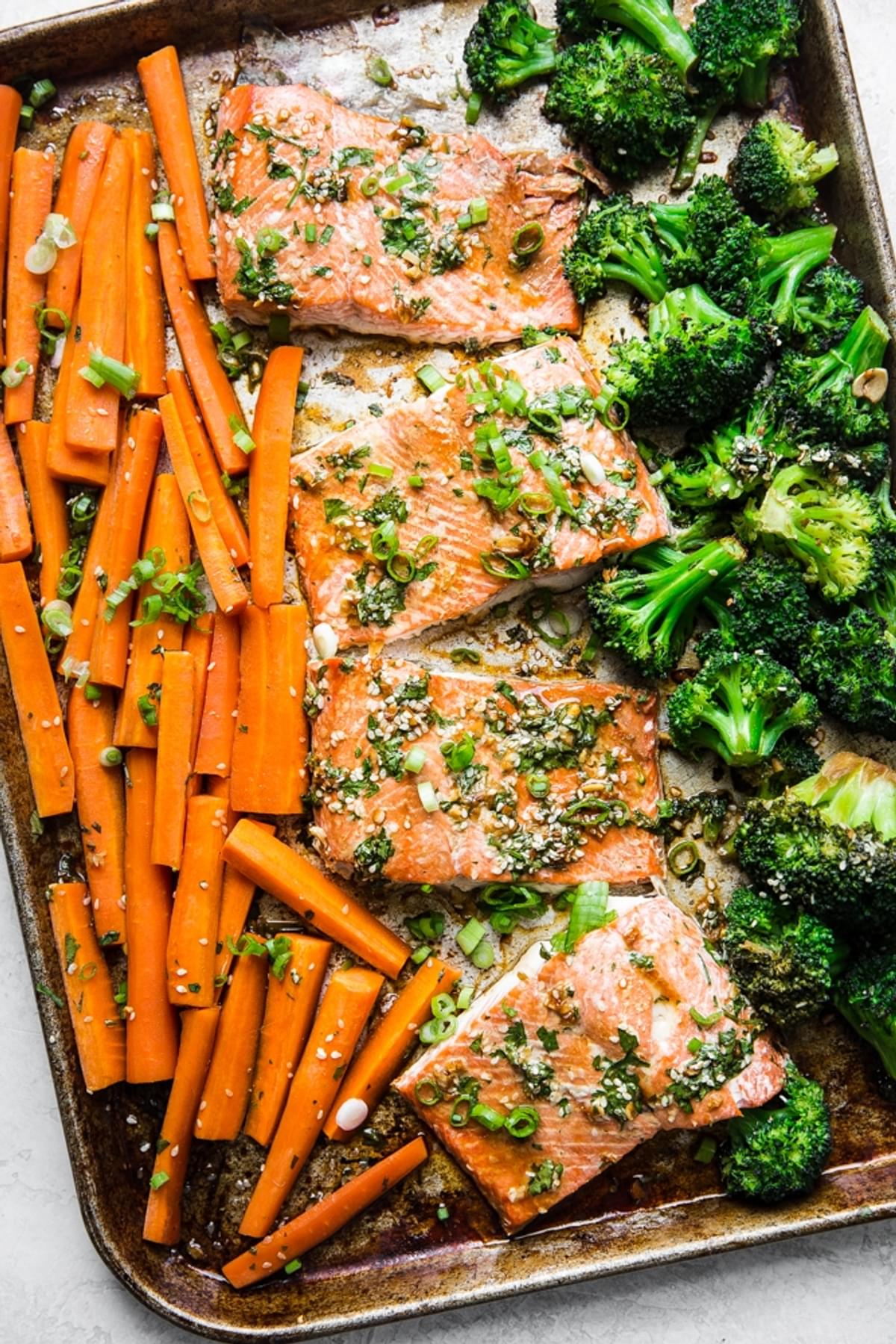 Baking sheet with carrots, salmon and broccoli with a teriyaki sauce
