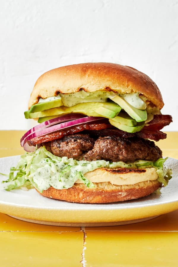 a homemade avocado burger with bacon, lettuce, red onion and jalapeño aioli