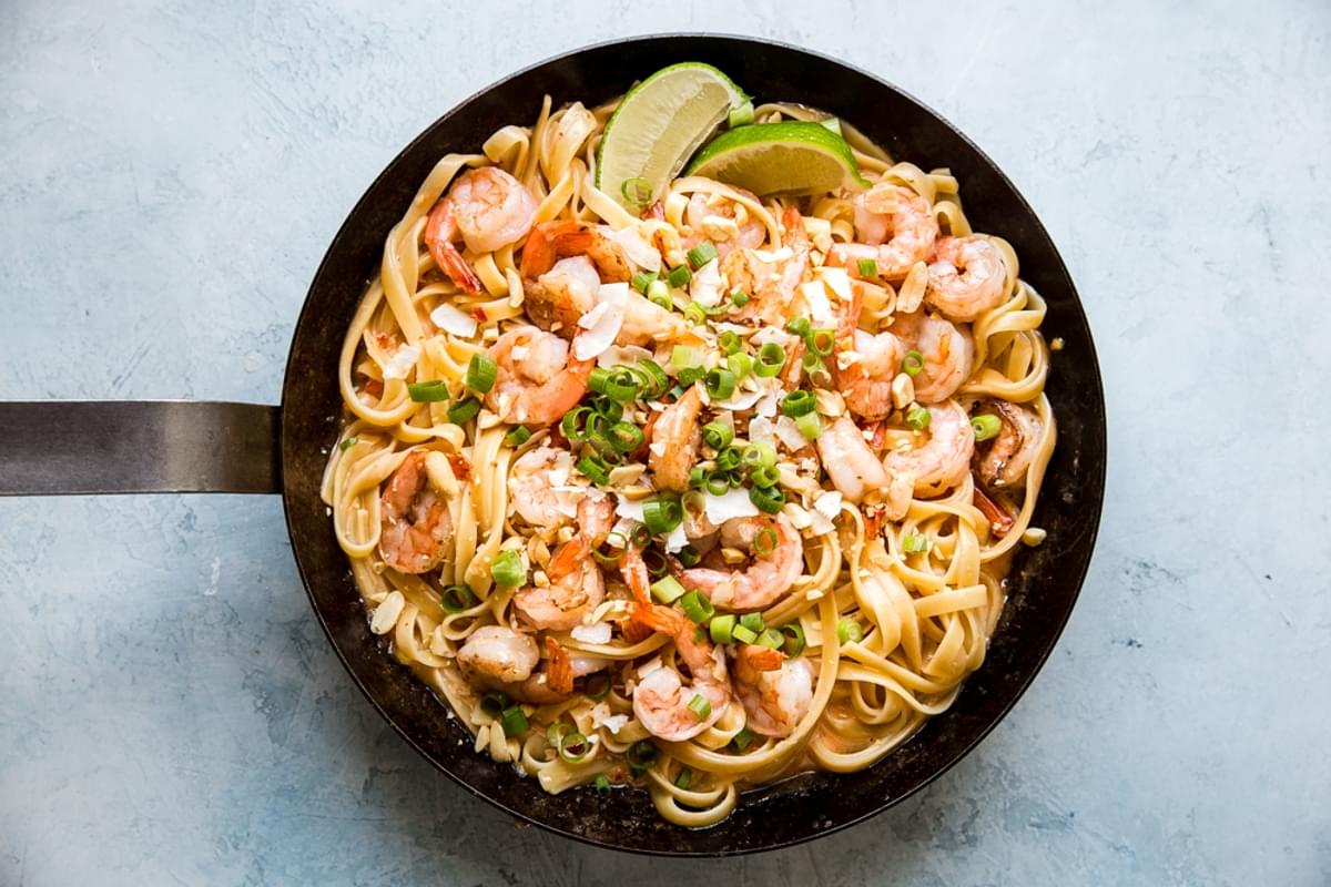 bang bang shrimp pasta with coconut flakes, peanuts and lime with a creamy sauce