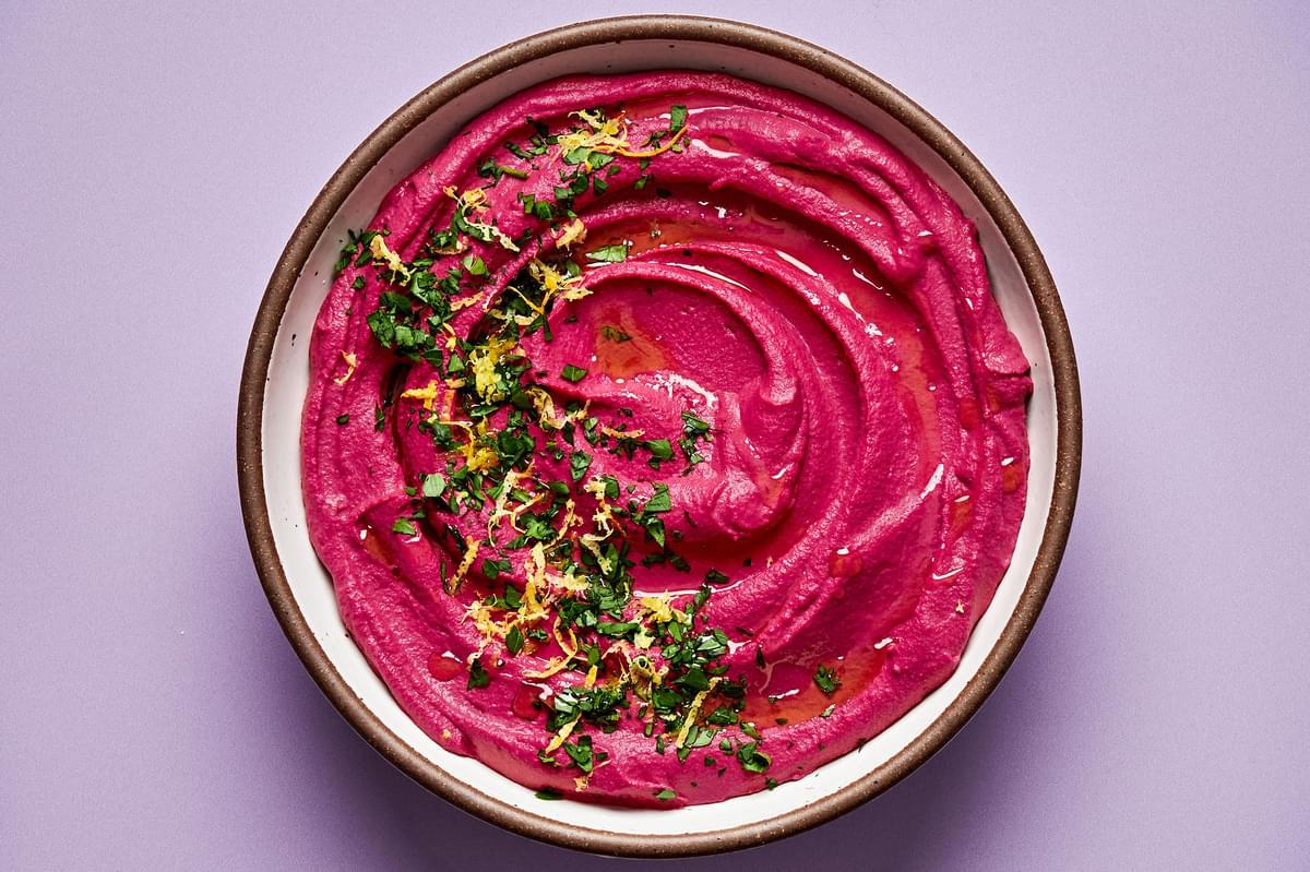 beet hummus in a bowl made with chickpeas, beets, tahini, olive oil, lemon zest & juice, red wine vinegar & spices