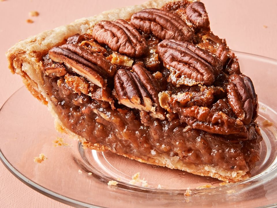 a slice of homemade bourbon pecan pie made with brown sugar, corn syrup, cinnamon, butter and vanilla