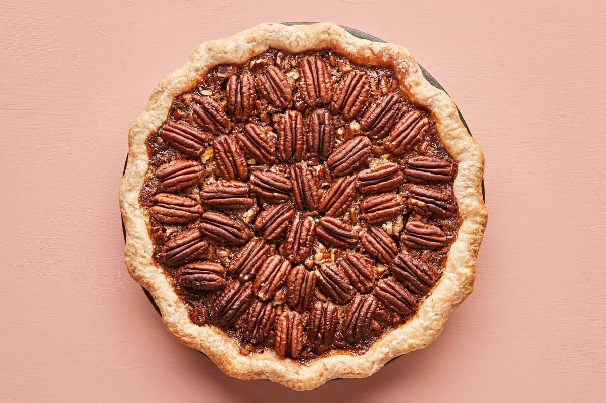 a homemade bourbon pecan pie made with brown sugar, corn syrup, cinnamon, vanilla butter and eggs