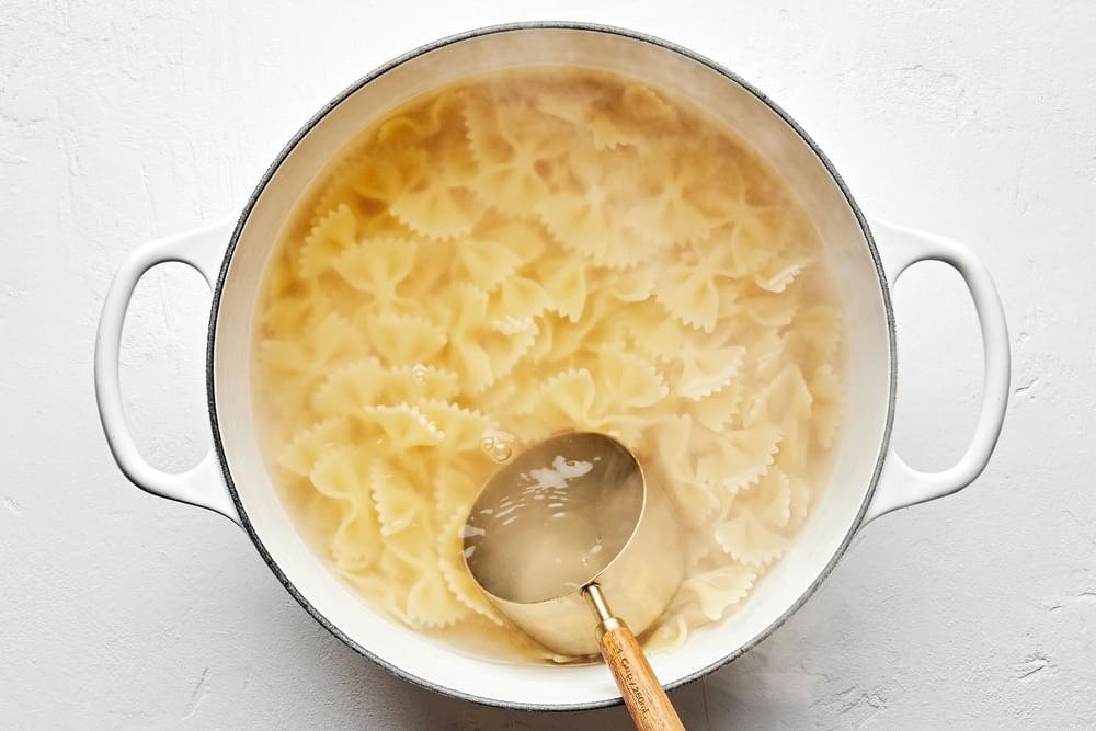 bow tie pasta noodles being cooked in salted water