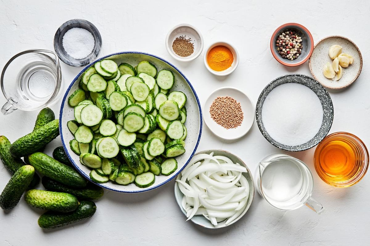cucumbers, sweet onion, garlic, mustard & celery seeds, peppercorns, vinegar, turmeric, sugar & salt in prep bowls