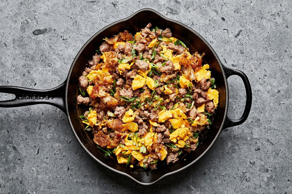 breakfast burrito filling in a skillet (potatoes, eggs, sausage and green onions)