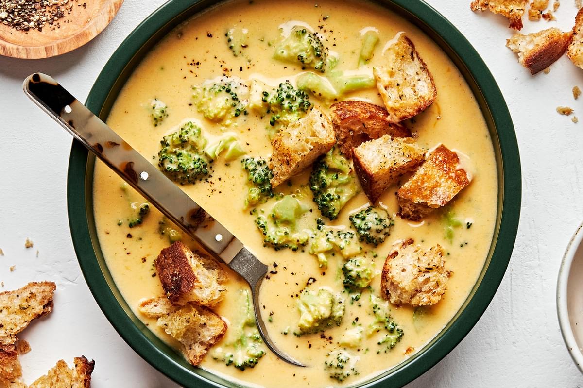 a bowl of homemade broccoli cheddar soup topped with croutons