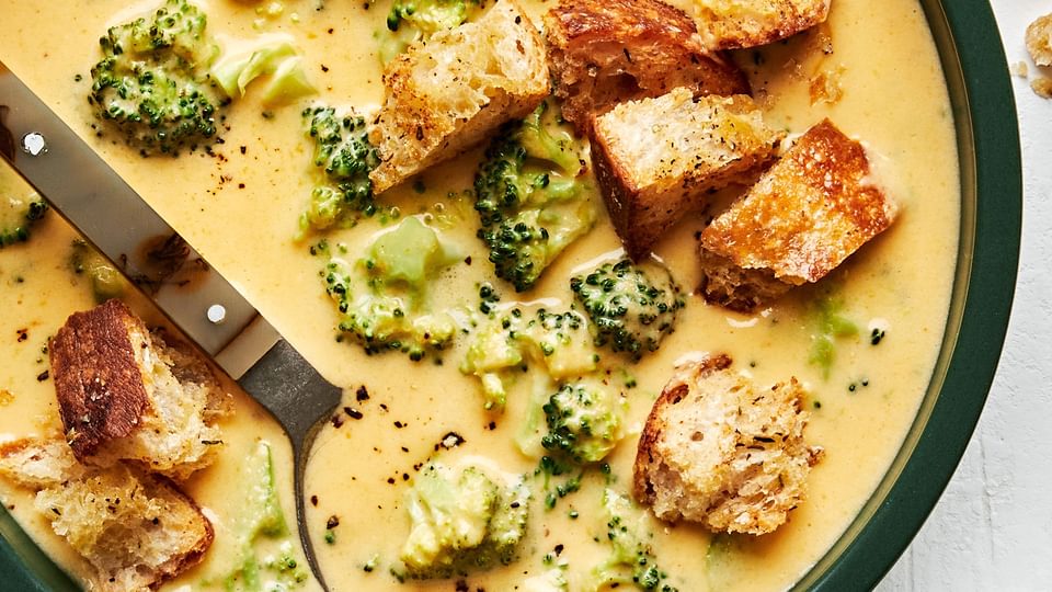 a bowl of homemade broccoli cheddar soup topped with croutons