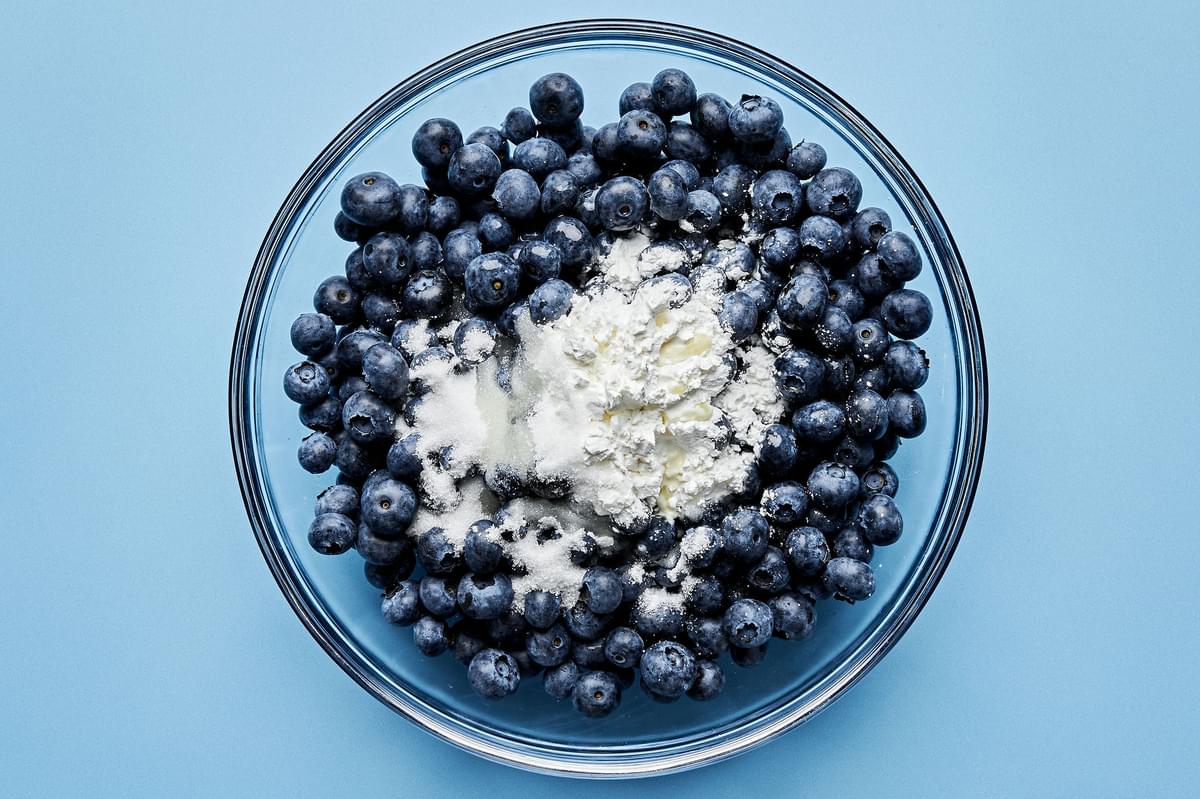 blueberries, salt, cornstarch, sugar, and lemon juice being combined in a bowl