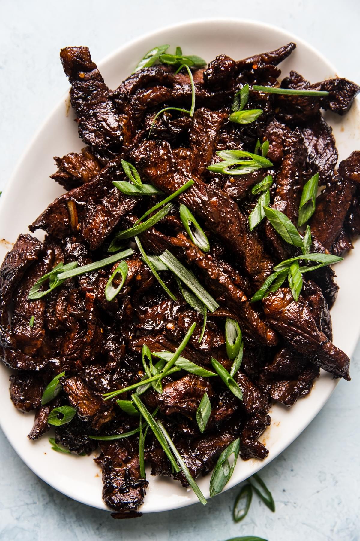 homemade Beef bulgogi sprinkled with green onions on a serving plate
