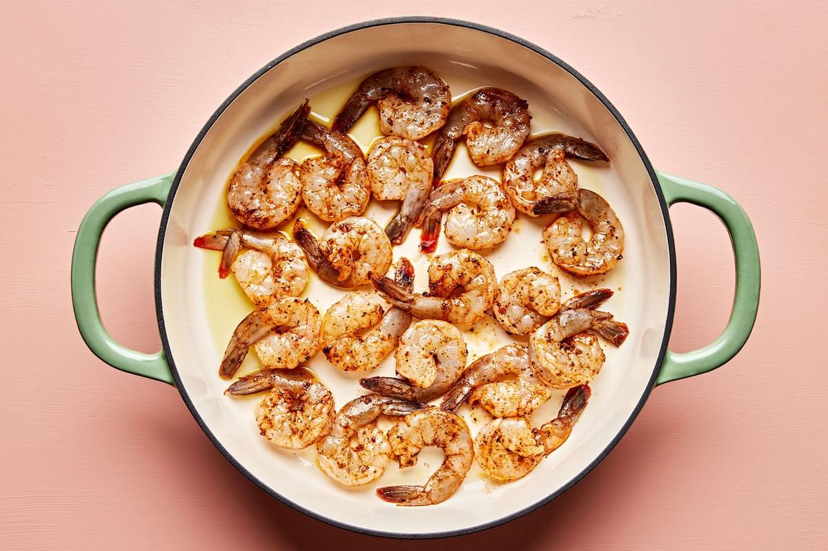 shrimp seasoned with olive oil, lemon juice, cajun seasoning & salt being cooked in a skillet