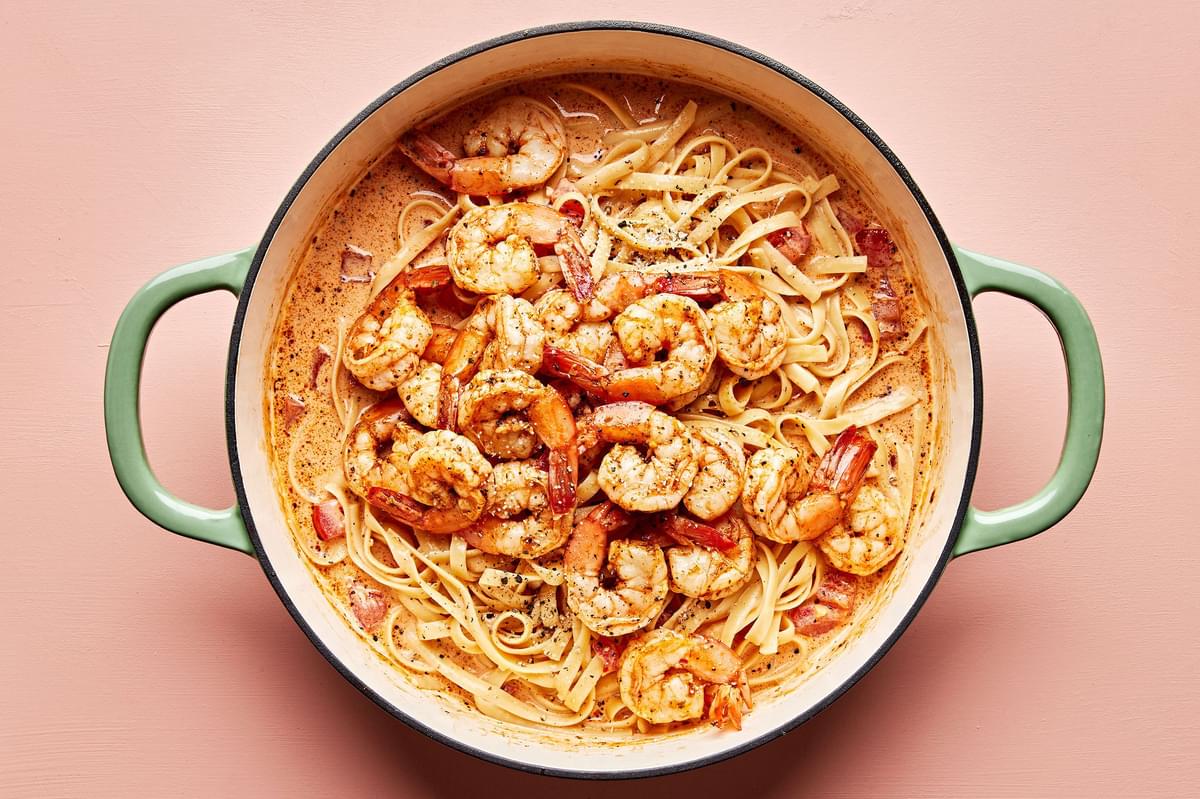 pasta and shrimp being tossed in a pot with homemade Cajun pasta sauce