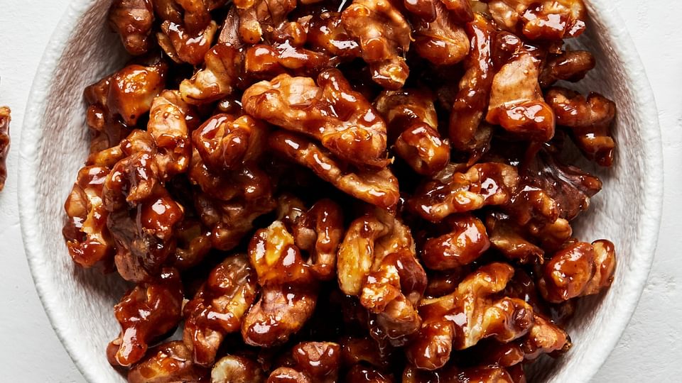 a bowl of homemade candied walnuts made with brown sugar, butter, salt and cayenne