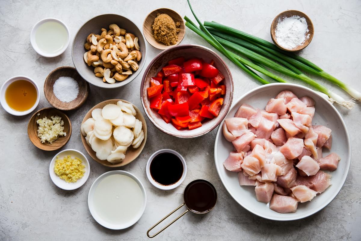 ingredients for cashew chicken laid out on a counter. Hoisin sauce, soy sauce, water chestnuts, red bell pepper, garlic