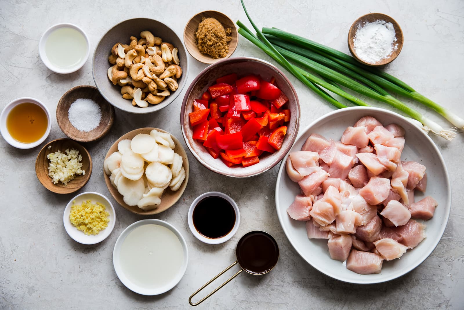 ingredients for cashew chicken laid out on a counter. Hoisin sauce, soy sauce, water chestnuts, red bell pepper, garlic