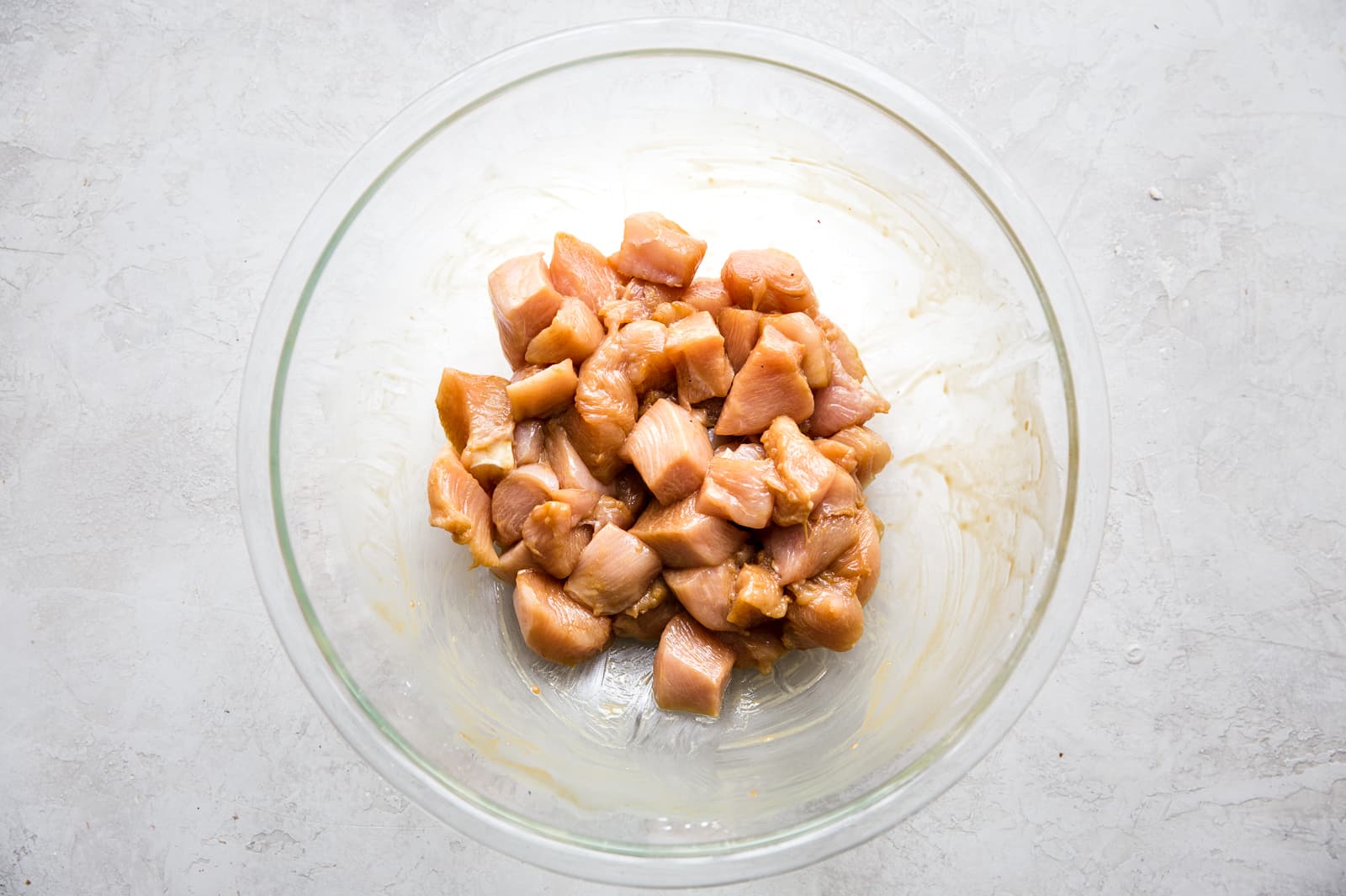 chicken pieces in a bowl with soy sauce, cornstarch and salt